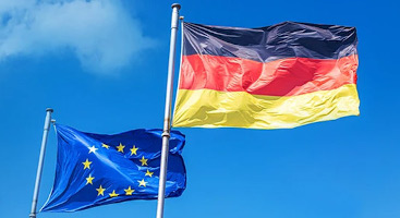 Die Europa und die Deutschland-Fahne vor blauem Himmel wehen im Wind