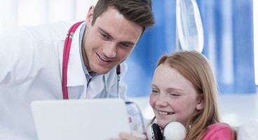 A doctor treats a child in hospital.