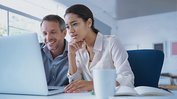 Two people working together on a laptop